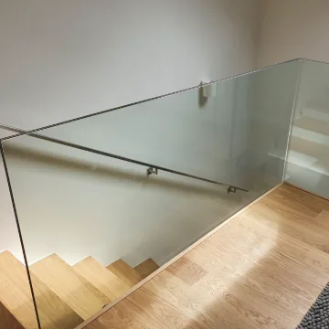 Glasgeländer mit Edelstahlhandlauf an einer Treppe