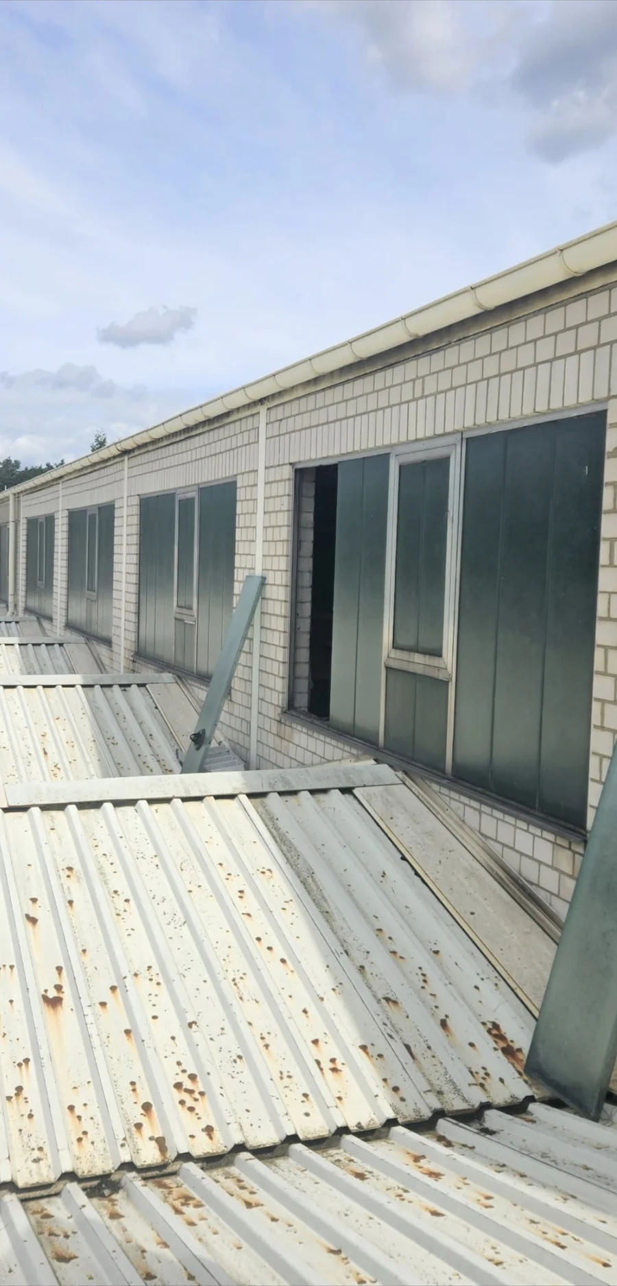 Profilbauglas an einer Industriehalle, ein Element ausgebaut, Arbeit vom Dach aus